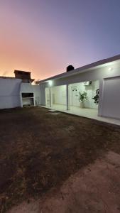 a large white building with a yard in front of it at Departamento Don Nico in San José de la Dormida