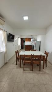 a dining room with a table and chairs and a kitchen at Departamento Don Nico in San José de la Dormida