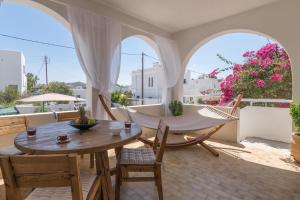 a patio with a table and chairs and a hammock at Grandpa's Yard in Adamantas
