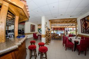 un ristorante con sedie e tavoli rossi e un bar di Privilege Fort beach Apartman Sveti Vlas 61m2 a Elenite