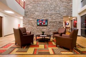 a lobby with chairs and a stone wall at Red Roof Inn & Suites Beaumont in Beaumont