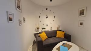 a living room with a couch and a clock on the wall at Apartment near Congress Centre I. in Prague
