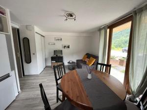 Appartement en station de ski في بورتيه بيومورينز: غرفة طعام مع طاولة وأريكة