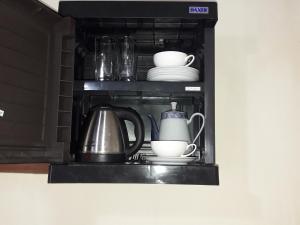 a shelf with dishes and utensils in a microwave at Ranjith Guest in Mirissa