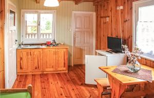 a kitchen with wooden flooring and a table and a television at Amazing Home In Ustronie Morskie With 1 Bedrooms And Wifi in Ustronie Morskie