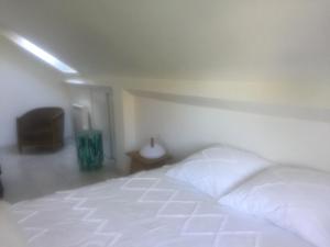 um quarto com uma cama branca e uma televisão em Vichy patrimoine mondial de l'Unesco em Bellerive-sur-Allier