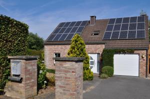 una casa de ladrillo con paneles solares en el techo en Bon séjour, en Theux