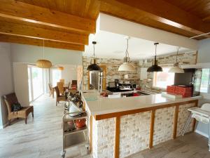 a kitchen with wooden ceilings and a brick wall at Kampaoh Cova Negra in Marchuquera