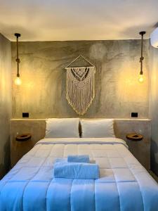 ein Schlafzimmer mit einem großen weißen Bett mit blauen Kissen in der Unterkunft Ariché Valladolid Hotel & Hostal in Valladolid
