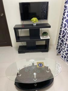 a glass table in a living room with a tv at DOT Accredited - ABIABI Courtyards in Baguio