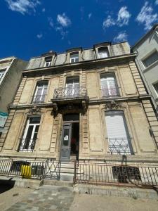 an old stone building with a porch and a balcony at Studio Zen in Boulogne-sur-Mer