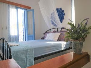 1 dormitorio con 1 cama con una maceta en una mesa en ~~ Sea Breeze covered house ~~, en Mókhlos