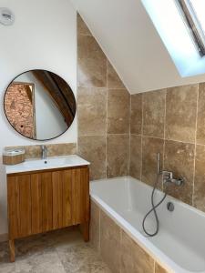 Gîte Les 27 في سان دوني لي فيرمونت: حمام مع حوض ومغسلة ومرآة