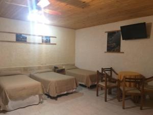 a room with three beds and a flat screen tv at Regine Hotel in San Rafael