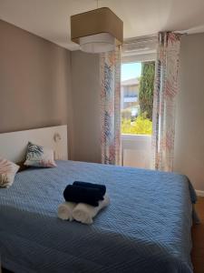 sypialnia z łóżkiem z niebieską pościelą i oknem w obiekcie LE MONTI appartement proche MEETT, Aéroport Blagnac, Airbus, Golf international de Seilh w mieście Mondonville