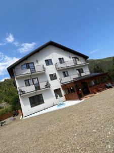 a large white building with balconies on top of it at Casa Marci Teo in Moieciu de Jos