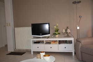 a living room with a tv on a white entertainment center at Zijdezeezicht Martiny 0202 in Middelkerke