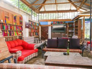 a library with red couches and a tv and books at Arusha Safari Hostel in Arusha