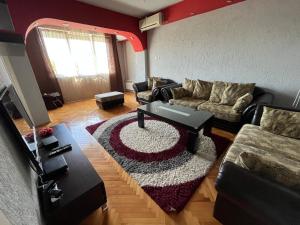 een woonkamer met een bank en een tafel bij Mickitos MM Apartment in Skopje
