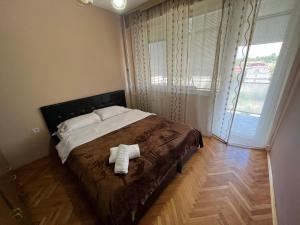 een slaapkamer met een bed met twee handdoeken erop bij Mickitos MM Apartment in Skopje