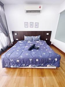 a bedroom with a bed with a blue comforter at Connected train 3 Bedrooms - ABOVE KLGATEWAY MALL 14 in Kuala Lumpur