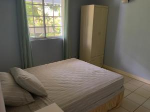 a small bedroom with a bed and a window at Marveys Place Apartment in Castries