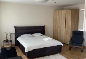 um quarto com uma cama grande e uma cadeira azul em S&A apartamentai em Panevėžys