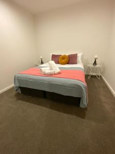 a bedroom with a bed with two towels on it at New 2 Bed 2 Bath Apt at The Heart of Canberra - 2 Car Spaces in Canberra