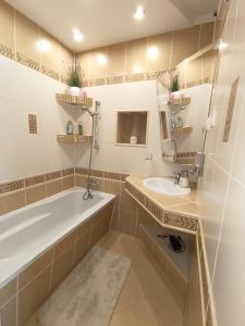 ein Badezimmer mit einer Badewanne und einem Waschbecken in der Unterkunft Relax Apartment Suwałki in Suwałki