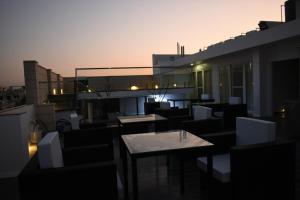 a balcony with tables and chairs on a building at Grande Azure in Jaipur
