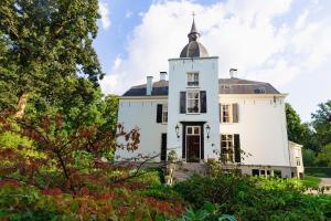 a white house with a tower on top of it at De Heerlijkheid Loenen Bed en Breakfast in Slijk-Ewijk