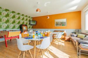 a living room with a table and chairs and a couch at Clubhouse Gites in Beussent