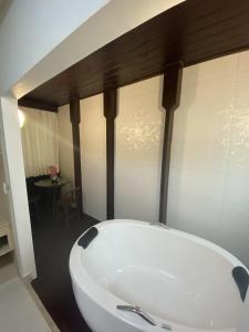 a white bath tub in a room with a table at Pousada Retiro das Ilhas in Bombinhas