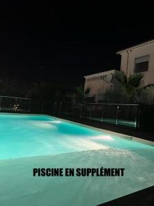 uma piscina à noite com as palavras pressão en suplemento em App T2 a Montpellier em Montpellier