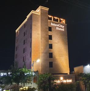 un edificio de hotel con un cartel en él por la noche en Jinhae Intercity Hotel, en Changwon