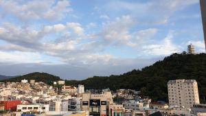 um horizonte da cidade com edifícios e uma montanha em Jinhae Intercity Hotel em Changwon