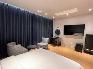 pokój hotelowy z łóżkiem i telewizorem z płaskim ekranem w obiekcie Jinhae Intercity Hotel w mieście Changwon