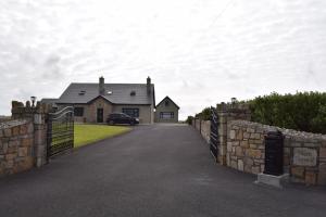 a house with a gate in front of a driveway at Cosy two bedroom cottage on the Mullet Peninsula in Ballina