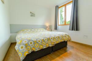a bedroom with a bed with a yellow and white blanket at Clubhouse Gites in Beussent