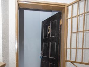 a black door in a room with a window at Ekasi Apartments in Mbabane