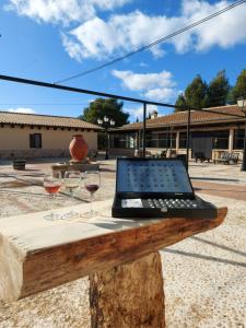 - un ordinateur portable sur une table avec deux verres de vin dans l'établissement HOTEL ENOTURISMO MAINETES, à Fuente-Álamo