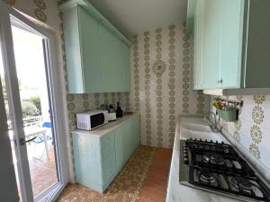 cocina con armarios verdes y microondas en VILLA GIORGIA, en Savelletri di Fasano 24 fotos más