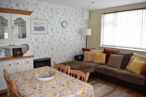 sala de estar con mesa y sofá en Cosy two bedroom cottage on the Mullet Peninsula, en Ballina