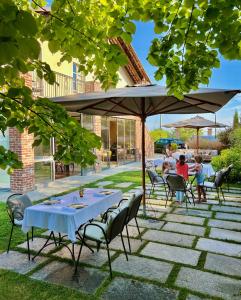 una mesa y sillas bajo una sombrilla en un patio en MiaClara Relais en Alba