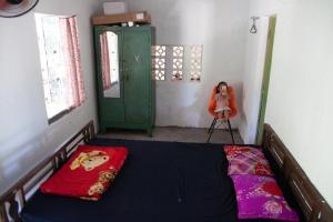 una camera con un letto e una bambola su una sedia di Thôn Hoa Sen a Thôn Xuân Lỗ