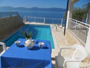 une table avec un chiffon bleu à côté d'une piscine dans l'établissement Apartments and rooms with a swimming pool Brist, Makarska - 15620, à Brist