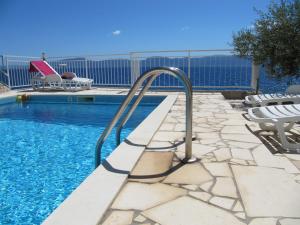 a swimming pool with a metal hand rail next to a swimming pool at Apartments and rooms with a swimming pool Brist, Makarska - 15620 in Brist