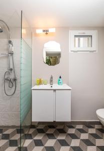 La salle de bains est pourvue d'un lavabo blanc et d'une douche. dans l'établissement The Old Town Vintage 2-Bedroom Jewel, à Plovdiv