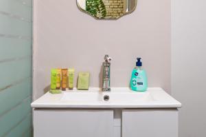 - un lavabo dans la salle de bains avec du savon et un distributeur de savon dans l'établissement The Old Town Vintage 2-Bedroom Jewel, à Plovdiv