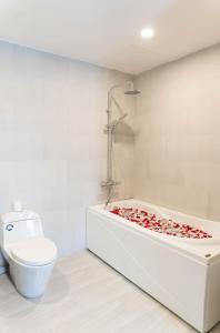 a bathroom with a bath tub with a toilet at Henry Crown Hotel in Thôn Trường Giang
